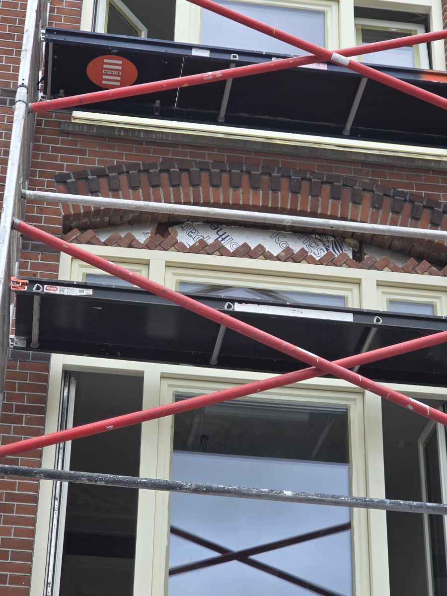 Steigerwerk voor een jaren-30 gevel waar een rollaag boven een venster wordt hersteld